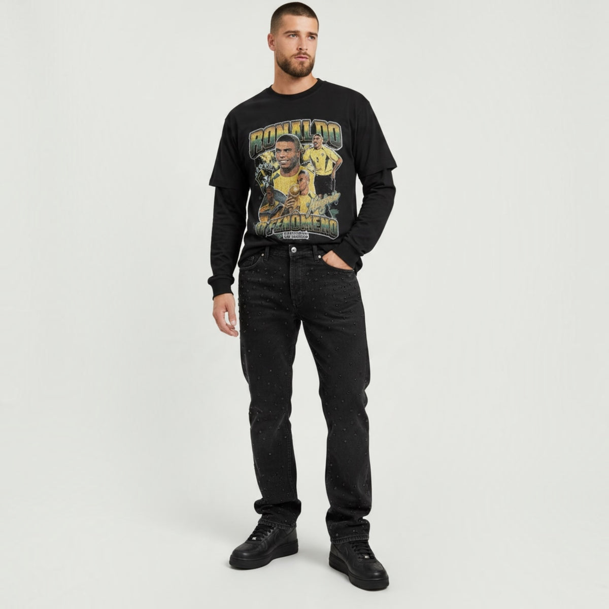 Modello indossa maglietta nera a maniche lunghe Chulo Store con grafica vintage di Ronaldo Il Fenomeno e jeans scuri