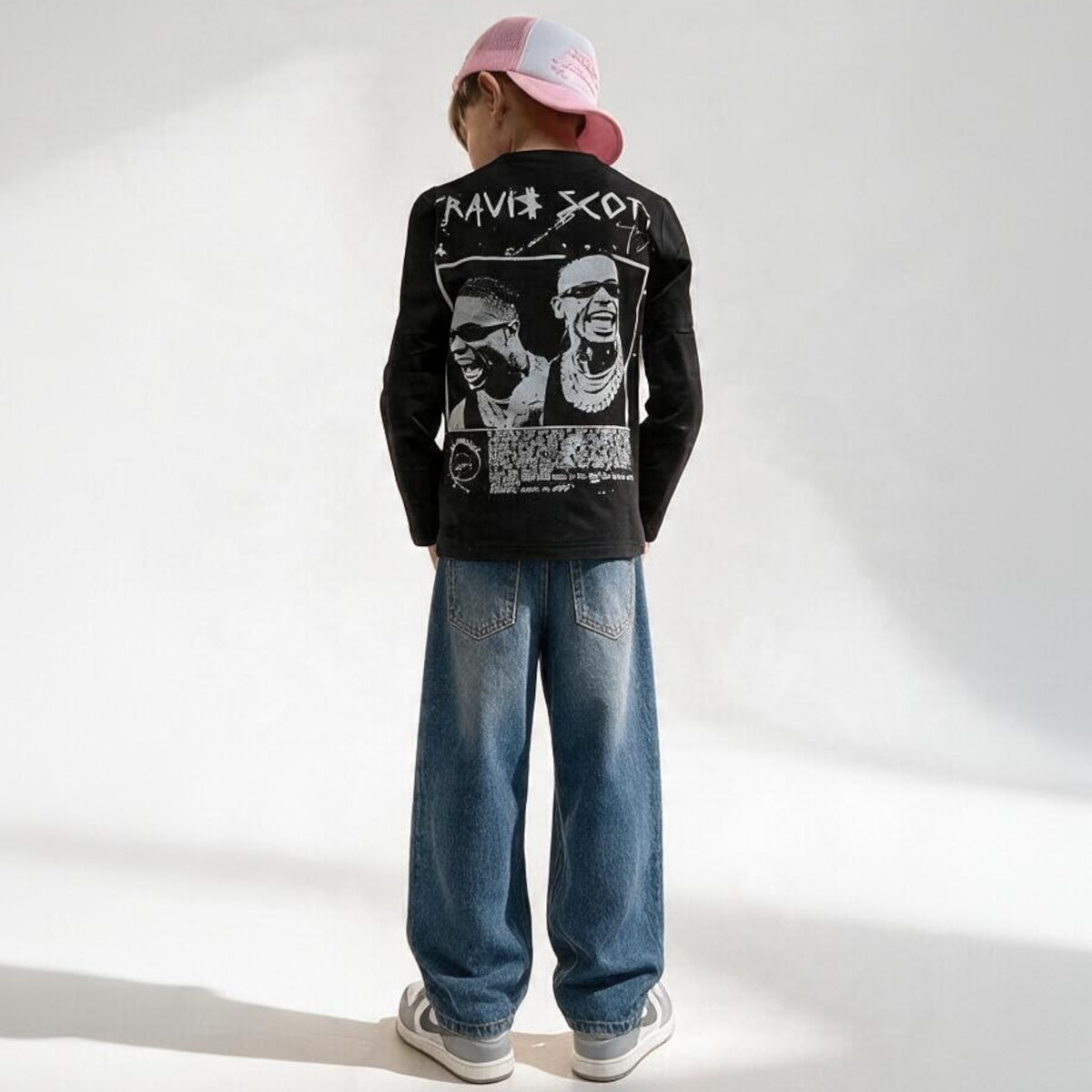 Ragazzo indossa maglietta nera a maniche lunghe Chulo Store con grafica Travis Scott sul retro e jeans baggy