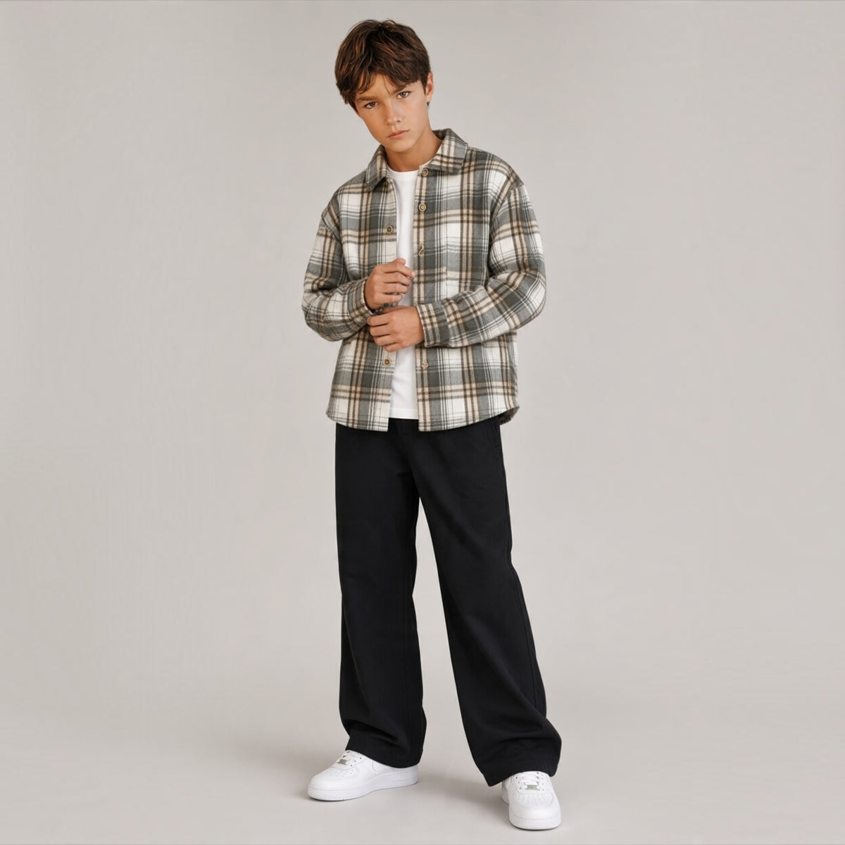 Ragazzo indossa camicia a quadri in flanella Chulo Store sopra una t-shirt bianca e pantaloni neri