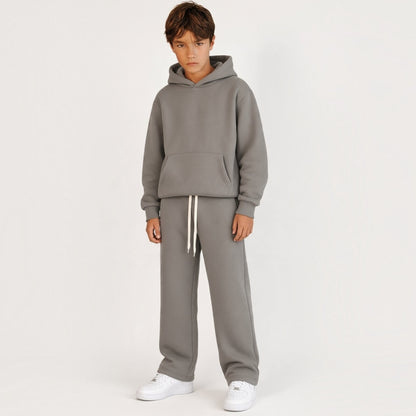 Ragazzo indossa tuta Chulo Store grigia con felpa con cappuccio e pantaloni sportivi a gamba dritta
